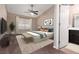 Bedroom featuring neutral decor, a large window, ensuite bath, a ceiling fan and a comfortable bed at 317 Brent Ct, Henderson, NV 89074
