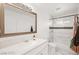 This bathroom features modern white cabinetry, bath tub with white tile and shower head at 3208 Alcoa Ave, Las Vegas, NV 89102