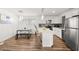 Bright, modern kitchen features white cabinets, stainless steel appliances, island, and dining area at 3208 Alcoa Ave, Las Vegas, NV 89102