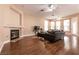 Cozy living room with hardwood floors, fireplace, ceiling fans, and lots of natural light through the windows at 3684 Miguels Ln, Las Vegas, NV 89120