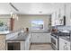 Bright kitchen with white cabinets, stainless steel appliances, and a breakfast bar with granite countertops at 3871 Trellis View Ave, Las Vegas, NV 89115