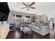 Cozy living room featuring a large sectional sofa, ceiling fan, and lots of natural light at 3871 Trellis View Ave, Las Vegas, NV 89115