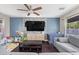 Comfortable living room with a large TV, ceiling fan, and gray sofa, perfect for relaxing at 3871 Trellis View Ave, Las Vegas, NV 89115