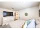 A bright bedroom showcases a large TV, a white dresser, and a patterned quilt on the bed at 4145 Nopal Serrano Ave, Las Vegas, NV 89141