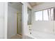 Bathroom showcasing a soaking tub, a window with blinds, and a separate shower stall with glass doors at 426 Lost Trail Dr, Henderson, NV 89014