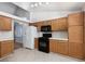 Functional kitchen featuring wood cabinetry, white appliances, and tiled countertops at 426 Lost Trail Dr, Henderson, NV 89014