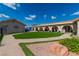 Expansive backyard featuring manicured artificial turf, gravel accents, flower beds, and a covered patio at 465 E Robindale Rd, Las Vegas, NV 89123