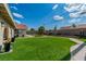Large backyard with artificial turf, mature landscaping, a block wall, and a covered patio at 465 E Robindale Rd, Las Vegas, NV 89123