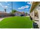 Spacious backyard featuring well-maintained artificial grass and the home's exterior with ample room at 465 E Robindale Rd, Las Vegas, NV 89123