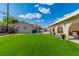 Expansive backyard showcasing the lush artificial turf and covered patio, perfect for outdoor entertaining at 465 E Robindale Rd, Las Vegas, NV 89123