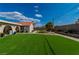 Expansive backyard with lush artificial turf, gravel landscaping, and a mature palm tree centerpiece at 465 E Robindale Rd, Las Vegas, NV 89123