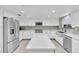 Modern kitchen featuring stainless steel appliances, white cabinetry, and a center island for meal preparation at 465 E Robindale Rd, Las Vegas, NV 89123