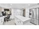 Bright kitchen featuring white cabinets, a center island, stainless steel appliances, and a built-in office space at 465 E Robindale Rd, Las Vegas, NV 89123