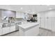 Spacious kitchen with white cabinets, island, stainless steel sink, modern countertops, and a functional built-in office at 465 E Robindale Rd, Las Vegas, NV 89123