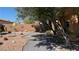 Peaceful backyard with desert landscaping, decorative wall art, and mature trees, creating a serene outdoor oasis at 4732 S Adriano Way, Pahrump, NV 89061