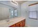 Bathroom featuring wood cabinets, large mirror, and natural light at 4841 Raw Umber Ct, Las Vegas, NV 89131