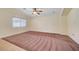 Cozy living room featuring carpeted flooring, natural light, and a modern ceiling fan at 4841 Raw Umber Ct, Las Vegas, NV 89131