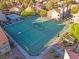 Aerial view of community tennis courts amid lush landscaping and red-tiled rooftops at 5042 S Rainbow Blvd # 206, Las Vegas, NV 89118