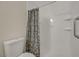 Modern bathroom with a toilet and walk-in shower featuring a patterned shower curtain at 5161 Lindell Rd # 206, Las Vegas, NV 89118