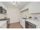 Well-lit kitchenette featuring white cabinets, stone countertops, and modern stainless steel appliances at 5161 Lindell Rd # 206, Las Vegas, NV 89118