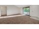 A spacious living room with a sliding glass door to balcony, carpeted floors, and two doors at 5161 Lindell Rd # 206, Las Vegas, NV 89118