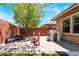 An outdoor play area with a playset, slide, and a cozy wicker couch for relaxing in a sand-filled backyard at 5568 Table Top Ln, Las Vegas, NV 89135