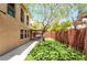 Green backyard, complete with easy maintenance artificial grass, offers shade from mature trees and is fully fenced at 5568 Table Top Ln, Las Vegas, NV 89135