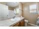 Bright bathroom with a single sink, white cabinets, and a shower-tub combination with a colorful curtain at 5568 Table Top Ln, Las Vegas, NV 89135