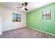 Spacious bedroom with a light-green accent wall, carpet flooring, a modern ceiling fan and natural light at 5568 Table Top Ln, Las Vegas, NV 89135