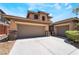 Exterior shot of the two-story house featuring a large driveway and attached two-car plus one-car garages at 5568 Table Top Ln, Las Vegas, NV 89135