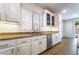 Close-up of the kitchen featuring white cabinets, stainless steel appliances, and a sink with a view of the yard at 5568 Table Top Ln, Las Vegas, NV 89135