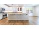 Bright kitchen featuring white cabinets, stainless steel appliances, and an island with counter seating at 5568 Table Top Ln, Las Vegas, NV 89135