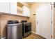 Functional laundry room featuring modern washer and dryer units, white cabinets and hardwood floors at 5568 Table Top Ln, Las Vegas, NV 89135