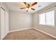 This bedroom features neutral walls, a ceiling fan, plush carpeting, and a window for natural light at 5732 Hornbrook St, North Las Vegas, NV 89031