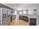 Spacious kitchen with stainless steel appliances, dark cabinets, and a convenient breakfast bar for casual dining at 5732 Hornbrook St, North Las Vegas, NV 89031