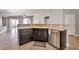 Stylish kitchen with stainless steel dishwasher and sink, dark cabinets, and breakfast bar at 5732 Hornbrook St, North Las Vegas, NV 89031