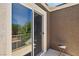 Balcony with street and trees, viewed through a glass sliding door at 6313 Pangea Ave, Las Vegas, NV 89139
