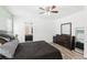 Large bedroom with wood-look floors, ceiling fan, and a view into the bathroom at 6313 Pangea Ave, Las Vegas, NV 89139
