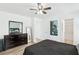 Spacious bedroom featuring wood-look floors, ceiling fan, and access to the bathroom at 6313 Pangea Ave, Las Vegas, NV 89139