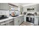 Modern kitchen with stainless steel appliances, gray cabinets, and stone countertops at 6313 Pangea Ave, Las Vegas, NV 89139