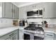 Stylish kitchen with stainless steel appliances, gray cabinets, and ample counter space at 6313 Pangea Ave, Las Vegas, NV 89139