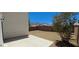 A spacious backyard featuring a concrete patio, desert landscaping, brick perimeter wall, and mountain views at 6615 Elk Creek Ln, Las Vegas, NV 89156