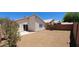 A spacious backyard featuring a concrete patio, desert landscaping, and a sliding glass door at 6615 Elk Creek Ln, Las Vegas, NV 89156