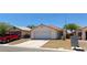 A front yard view of a single-story home with desert landscaping and a two-car garage at 6615 Elk Creek Ln, Las Vegas, NV 89156