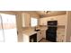 Bright kitchen featuring white cabinets, modern appliances, quartz countertops, and a door leading to the backyard at 6615 Elk Creek Ln, Las Vegas, NV 89156