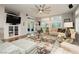 Bright living room featuring a ceiling fan, a large window, and access to the backyard at 6617 Golden Bit Ave, Las Vegas, NV 89131