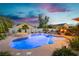 Sparkling swimming pool with a spa surrounded by desert landscaping and a twilight sky at 6617 Golden Bit Ave, Las Vegas, NV 89131