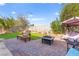 Charming backyard featuring a cozy seating area, lush green lawn, and brick pavers for low maintenance at 7032 Wonderberry St, Las Vegas, NV 89131