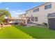 A spacious backyard with a patio, artificial grass, and mature trees, perfect for outdoor activities at 7032 Wonderberry St, Las Vegas, NV 89131