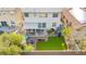 A large backyard with a covered patio, artificial grass, a fire pit, and block wall fencing at 7032 Wonderberry St, Las Vegas, NV 89131